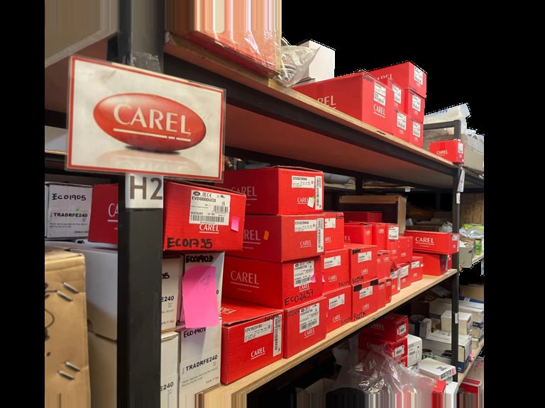 Retail shelf display with CAREL branded red boxes and signage in a store